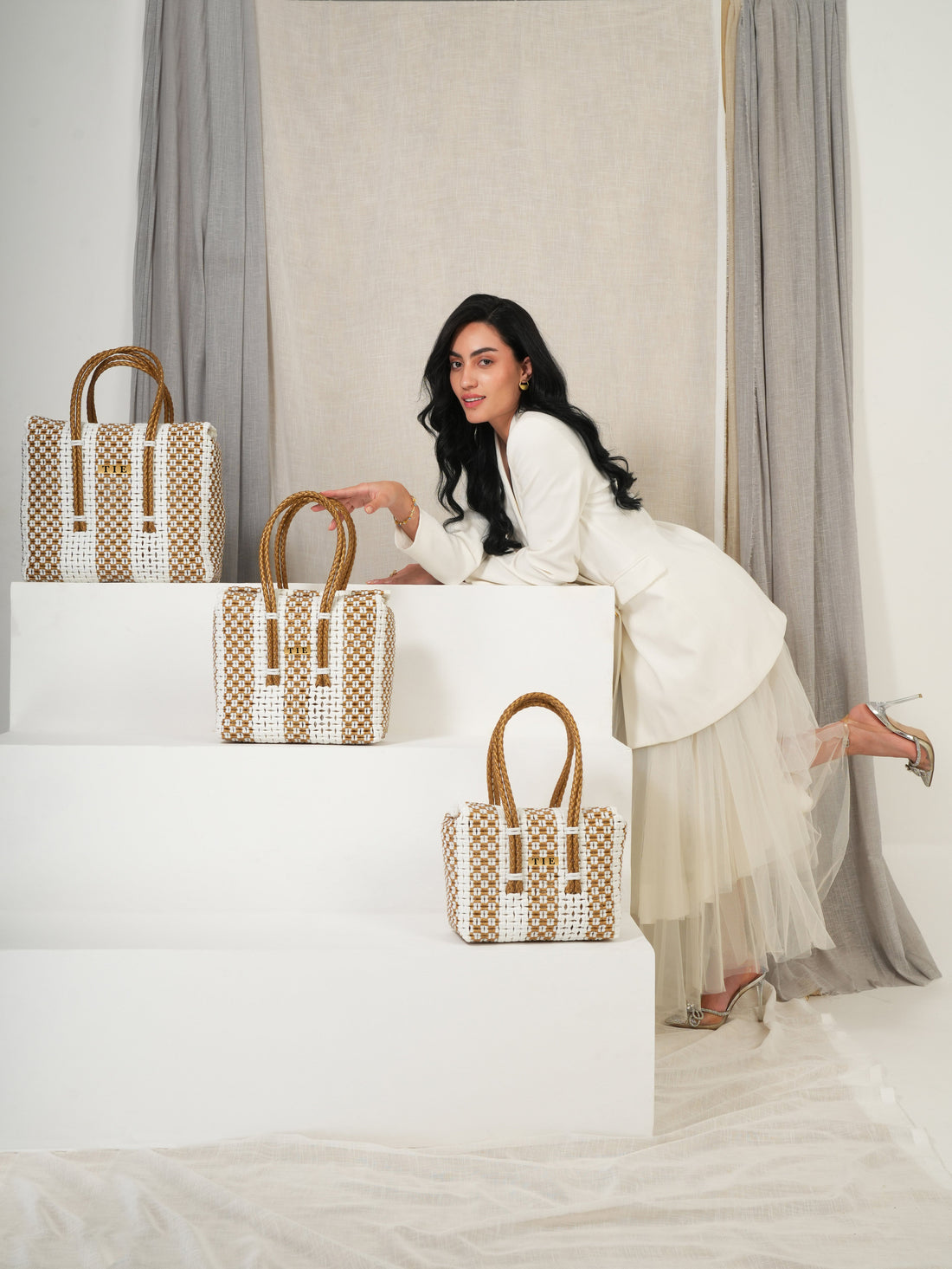 Woman sitting on a white box with three Closeweave Wire Basket in front of her, against a neutral background. | variant: White & Gold