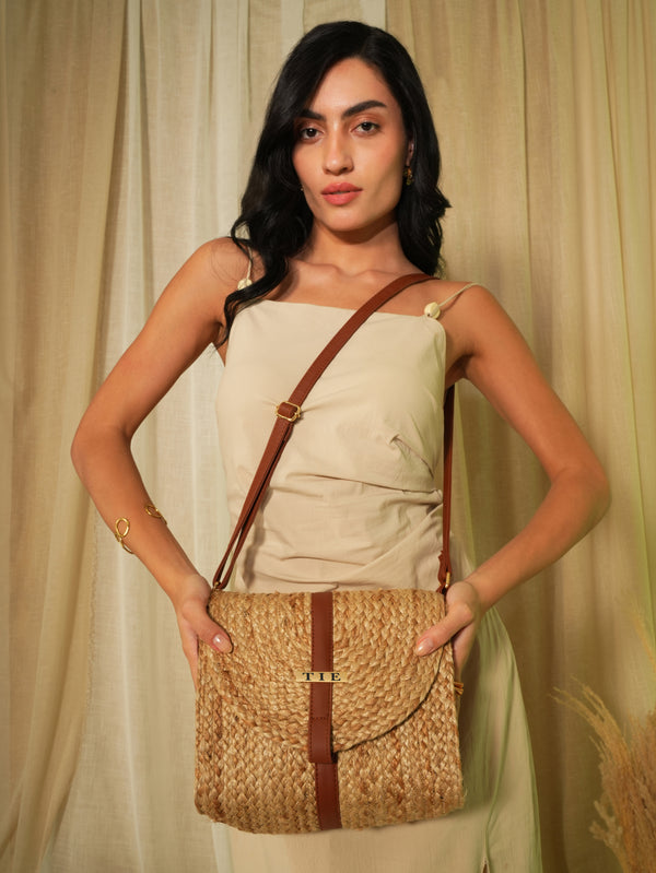 Woman holding a jute sling bag with a plain background