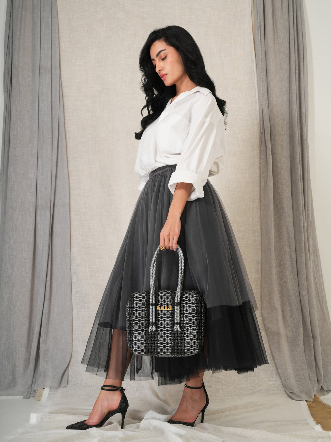 Woman holding a patterned Closeweave Wire Basket - Black & Silver against a neutral background