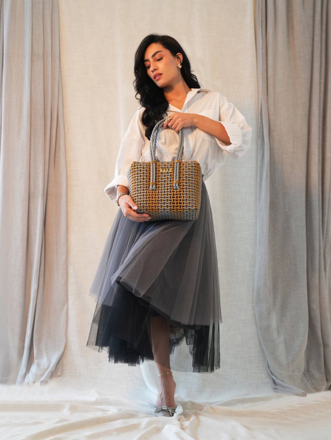 Woman holding a Closeweave Wire Basket (Gold & Silver) against a neutral background